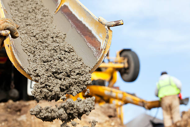 Construction Worker Guiding Cement Mixer Truck Trough stock photo
