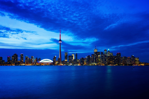 Toronto cityscape with CN Tower and baseball stadium at dusk, Ontario, Canada.