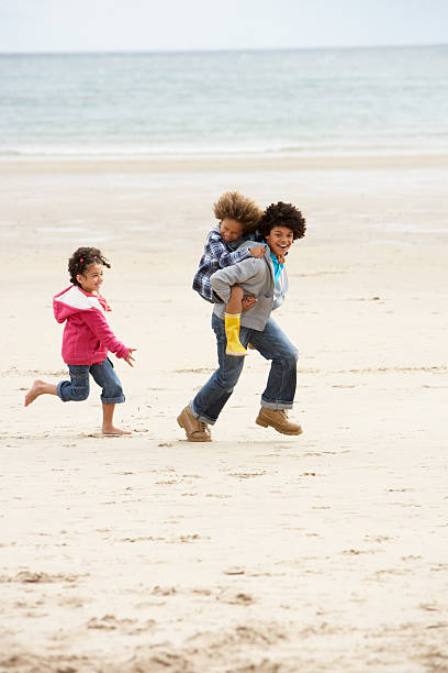istock Happy children playing piggyback on beach 165090597