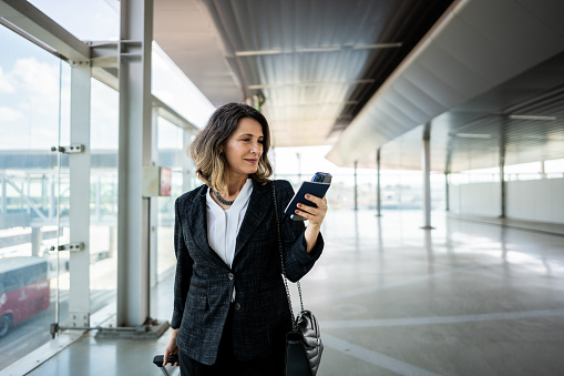 Businesswoman walking while use phone at the airport