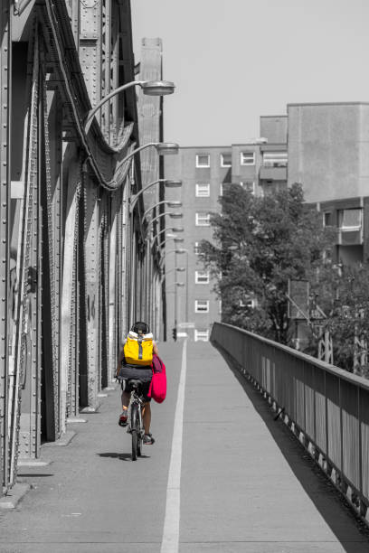 Germany, Berlin, July, 09, 2023 - Rear view of cyclist on a bridge - Berlin Wedding Swinemünder bridge