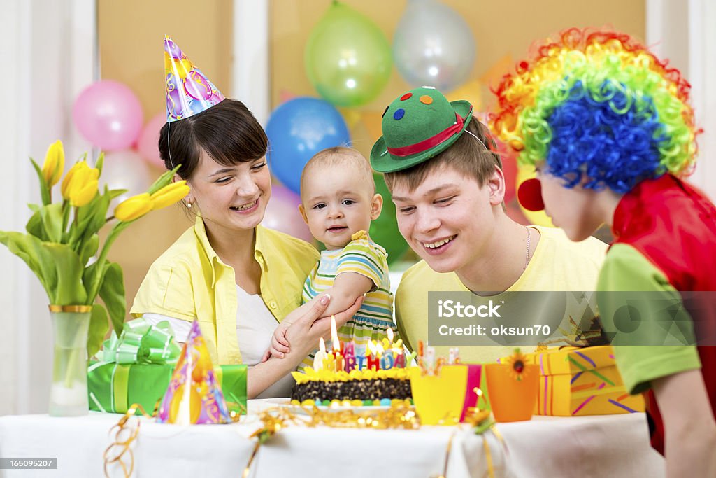 baby girl celebrating first birthday with parents and clown 12-23 Months Stock Photo