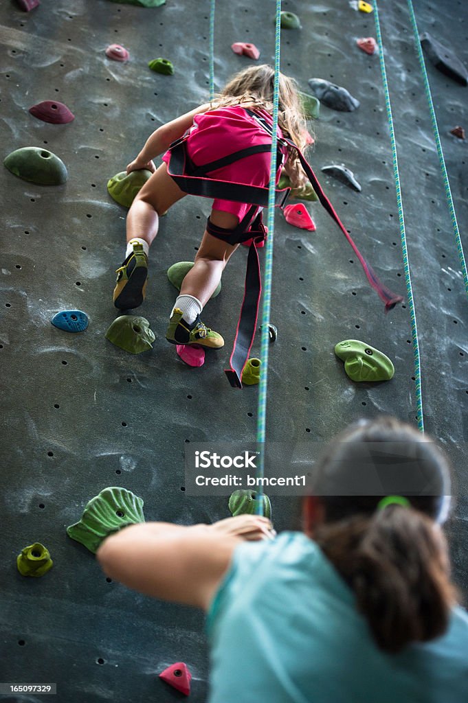 Mère assurage jeune fille au escalade intérieur de la salle de sport - Photo de Escalade libre de droits