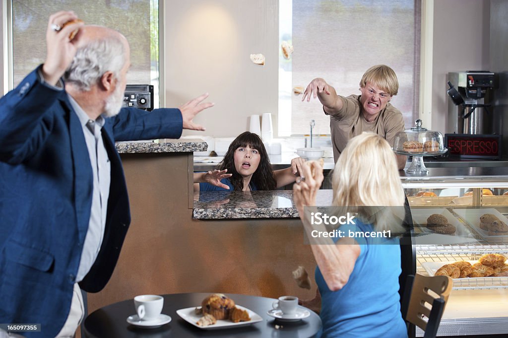 Cafe Food Fight Sometimes seniors and young adults just don't mix! Perhaps they were given poor service, or just disrespected, but these senior adult customers have started a food fight in a nice cafe! The employees aren't taking that either, they are fighting right back when not ducking behind their counter! Bagles captured in mid-air. Focus on the faces of the employees. Food Fight Stock Photo