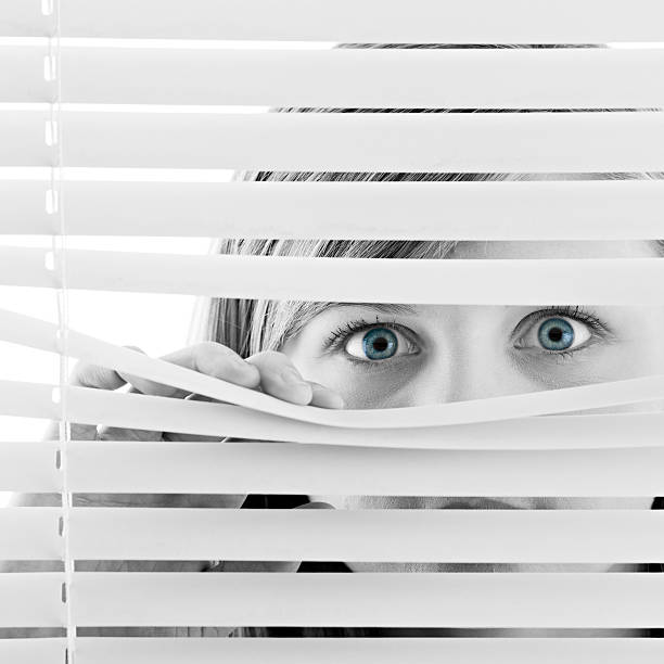 istock Woman Looking through Window Blinds 165097711