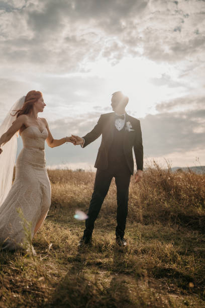 istock Happy bride and groom holding hands while walking in nature 1650979539