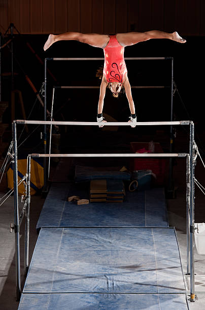 istock Female Gymnast In Handstand With Straddle On Uneven Bars 165102560