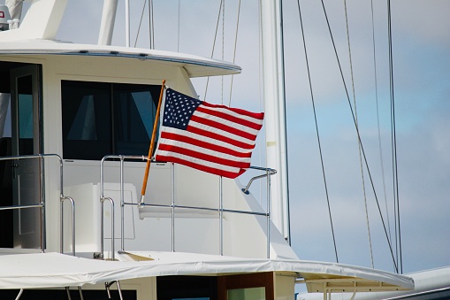 American flag blows in the sea wind on the aft of a yacht