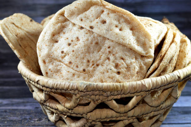 istock Traditional Egyptian flat bread with wheat bran and flour, regular Aish Baladi or Egypt bread baked in extremely hot ovens, it is the result of a mixture of wheat flour, yeast, salt and water 1651030320