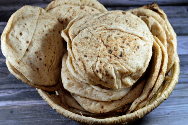 istock Traditional Egyptian flat bread with wheat bran and flour, regular Aish Baladi or Egypt bread baked in extremely hot ovens, it is the result of a mixture of wheat flour, yeast, salt and water 1651034038