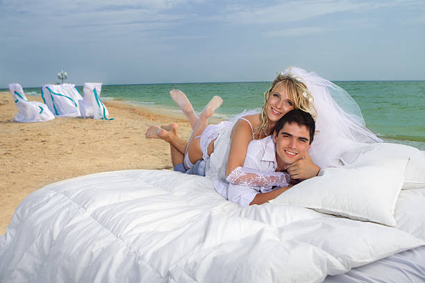 junges paar schlafen im bett - wedding beach groom bride stock-fotos und bilder