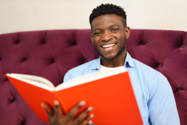 istock A young man happily studying a book in a library, embracing education and knowledge. 1651038360