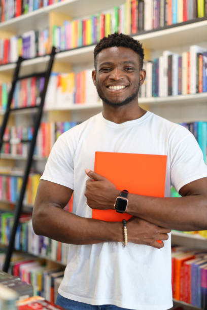 istock A young student with a cheerful smile, engrossed in studying amidst a library's bookshelves. 1651039447