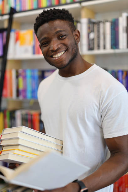 istock A content male student in a library, immersed in educational reading, exuding a cheerful demeanor. 1651039466