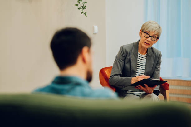 istock A serious psychotherapist is listening to a patient and taking notes while sitting in a session in the office. 1651040608