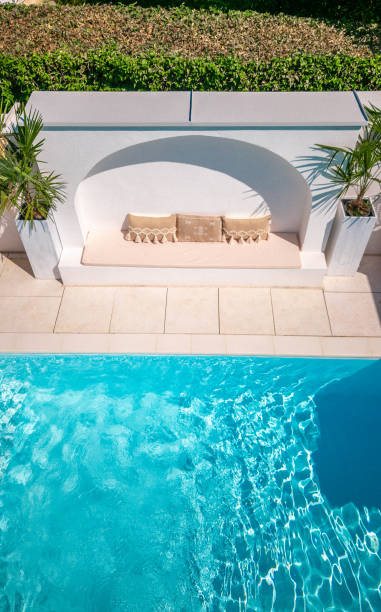 istock White Concrete arch bench in swimming pool garden area with boho decor 1651062542
