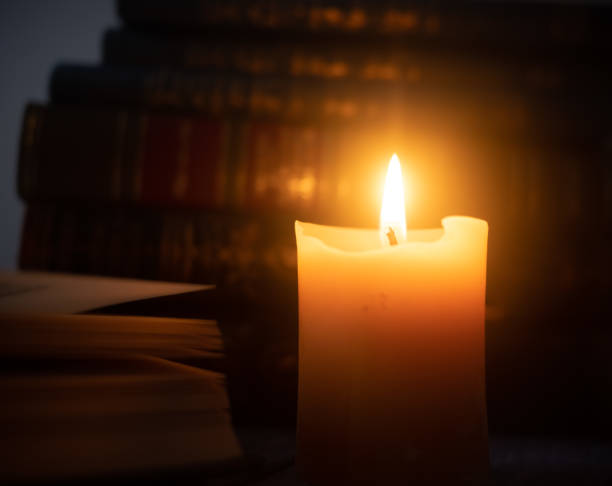 istock Candle in front of old books 1651062543