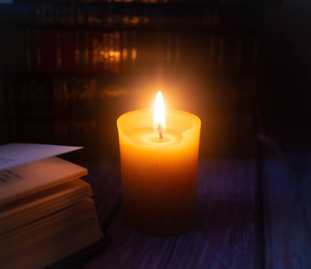 istock Candle in front of old books 1651063030