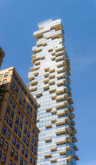 A traditional apartment building in Tribeca, Manhattan, dwarfed by a modern apartment skyscraper.