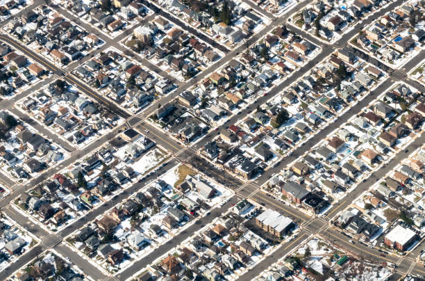 An aerial view of streets of houses in Long Island communities, with snow on the ground around the houses.