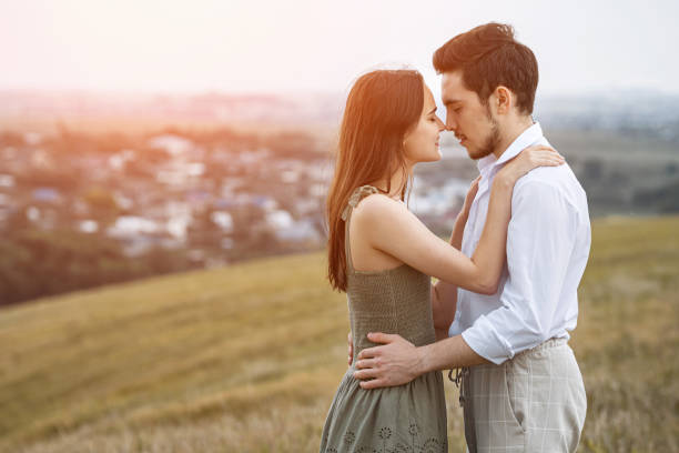 istock Sun rays fall on man and woman in love hugging on hill top 1651069980