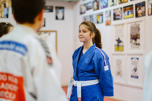 9 - 14 year old kids training judo with their sensei teacher at the dojo gym training ground.