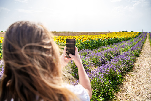 young woman tourist taking photos with smartphone. Young female tourist taking photos while on travel.