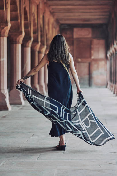 donna dell'asia orientale in vestito nero che danza con sciarpa traslucida tra le colonne del tempio antico - taj mahal mahal door temple foto e immagini stock