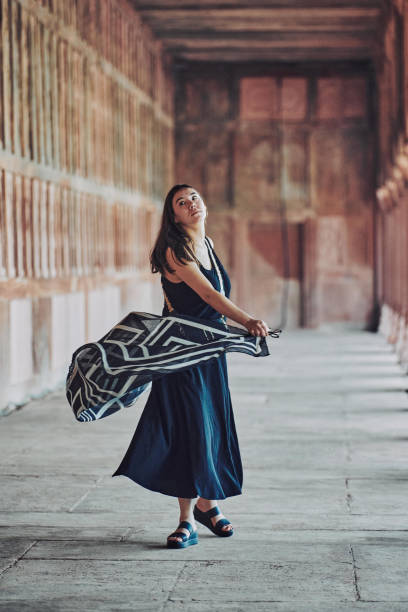 donna dell'asia orientale in vestito nero che danza con sciarpa traslucida tra le colonne del tempio antico - taj mahal mahal door temple foto e immagini stock