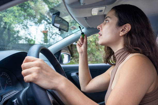 istock Distracted woman painting her eyelashes while driving 1651170207