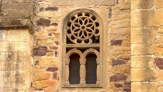 Close-up view of old stone  doorway arches in San Clodio monastery church, 13th century, Leiro, Ourense province, Galicia, Spain. Ornamental potted plants at both sides.