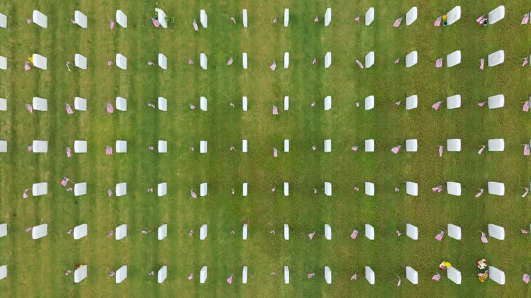 Large american army national cemetery with rows of white tombstones on green grass. Memorial Day concept