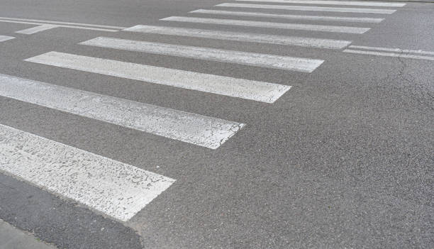 gepflasterter fußgängerüberweg, grau-weißer zebrastreifen, sicherheitszebra auf modernen fliesenweg - crossing zebra crossing crosswalk street stock-fotos und bilder