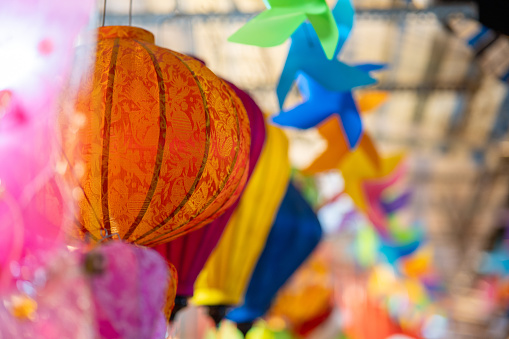 Decorated colorful lanterns hanging on a stand in the streets in Ho Chi Minh City, Vietnam during Mid Autumn Festival. Selective focus.