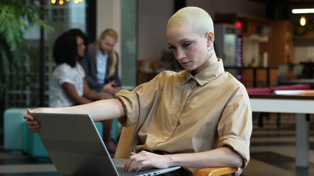 Modern woman using laptop at coworking