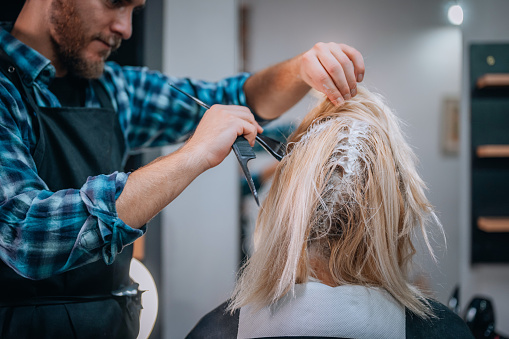 Close-up of a woman getting her hair dyed in a hair salon.