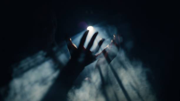 istock Hands outstretched towards the beam of light from the spotlight. 1651267408