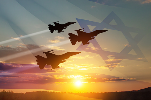 Aircraft silhouettes on background of sunset with a transparent waving Israel flag. Military aircraft. Independence day. Air Force Day.