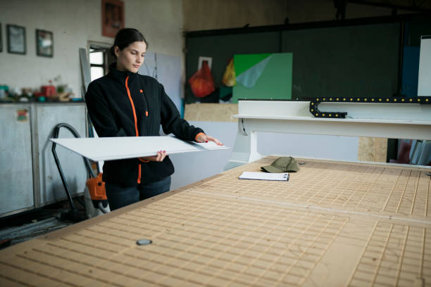 istock Young caucasian female worker working in a signboard making workshop 1651305476