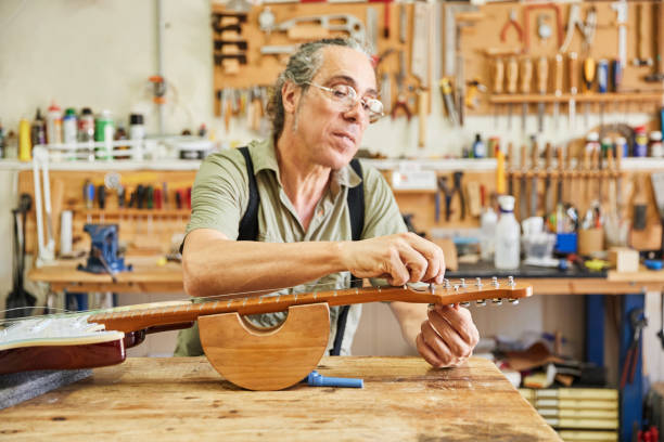 istock Luthier repairing the strings of an electric guitar in a workshop 1651308244