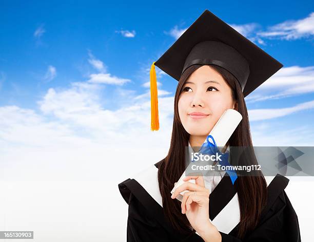 Graduate Mujer Agarrando Grados Foto de stock y más banco de imágenes de Adulto - Adulto, Adulto joven, Aire libre