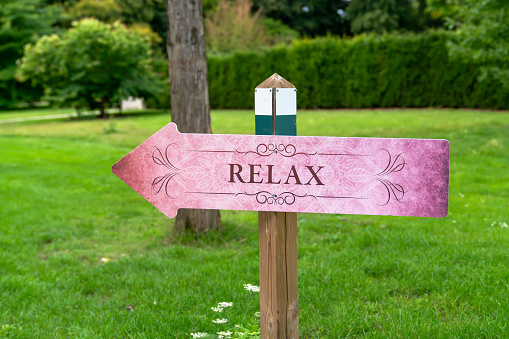 A sign saying relax on green grass.