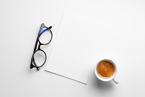 Blank paper mockup on white background with a coffee and glasses