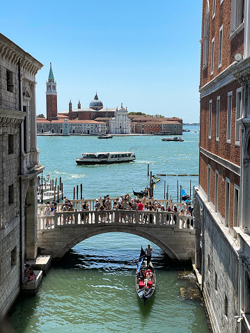 Rio del Palazzo, Venice, Italy - July 14, 2023: Stock photo showing close-up view of the Ponte della Paglia (Straw bridge) spanning Rio del Palazzo with crowds of tourists crossing the canal, on a sunny Summer's day.