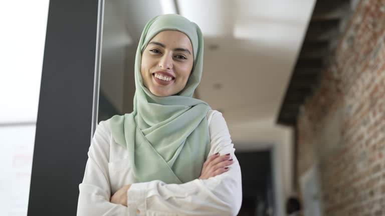 Young beautiful businesswoman wearing hijab psing for a shot at modern office hallway