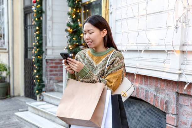 istock Young woman with Christmas presents using mobile banking 1651463710