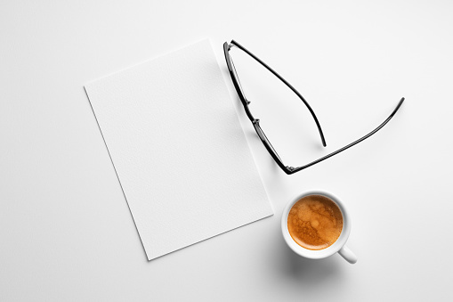 Blank paper mockup on white background with a coffee and glasses