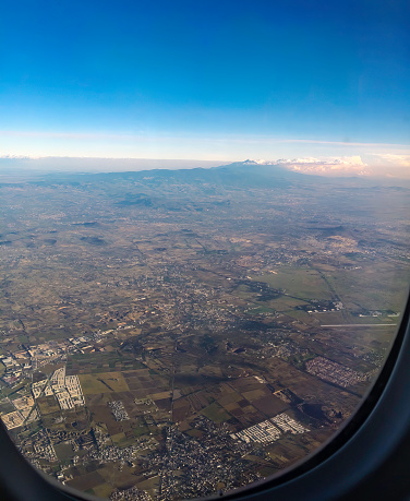 Flying over Mexico City, view of the Popocatepetl and Iztacciarhuatl volcanoes on a clear day