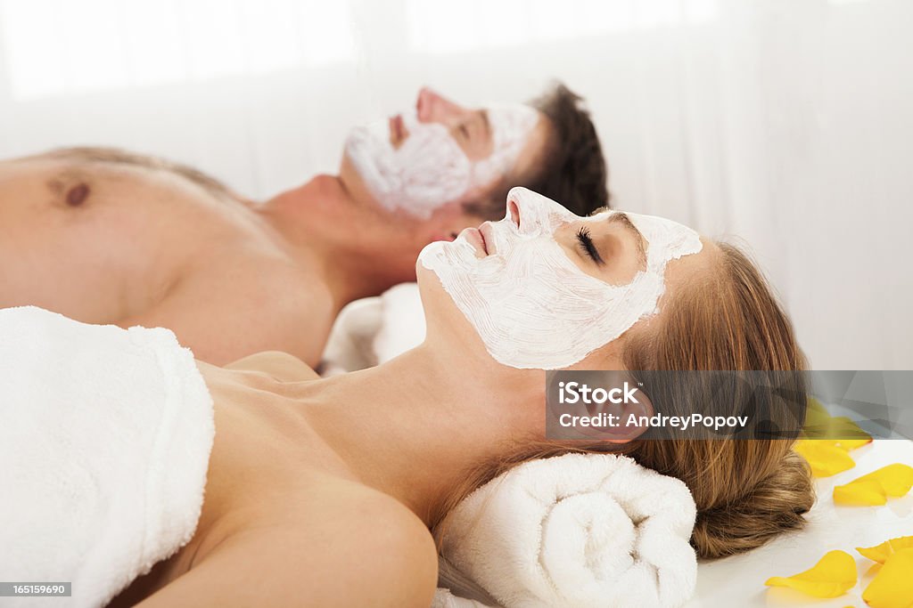 Man and woman in face masks Man and woman in face masks lying back on clean white towels in a spa relaxing Facial Mask - Beauty Product Stock Photo