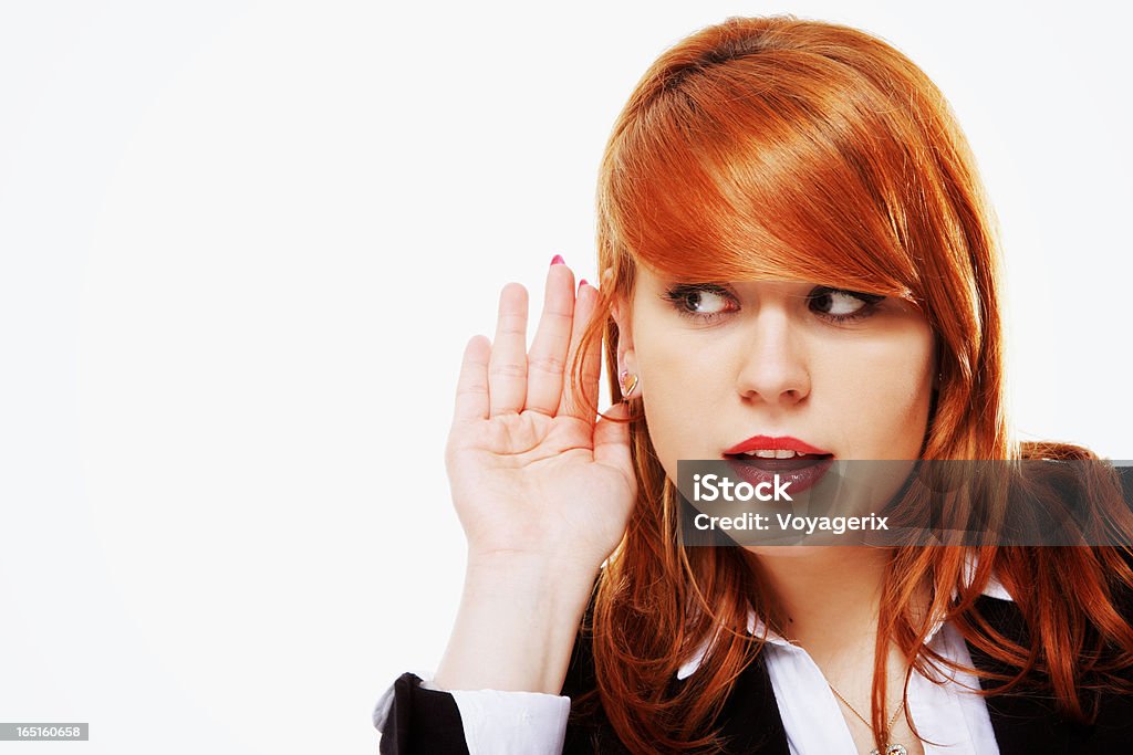 Business woman with hand to ear listening isolated Business woman with hand to ear listening over white background. Gossip Beauty Stock Photo